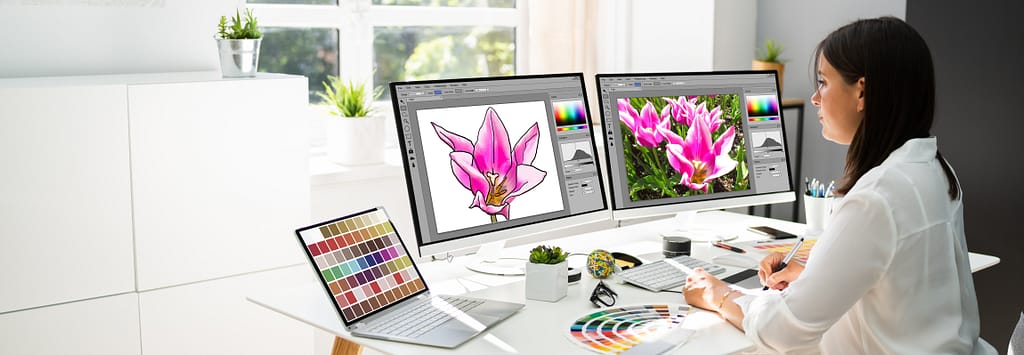 Artiste graphiste travaillant sur plusieurs écrans d'ordinateur et différents supports pour modifier votre visuel